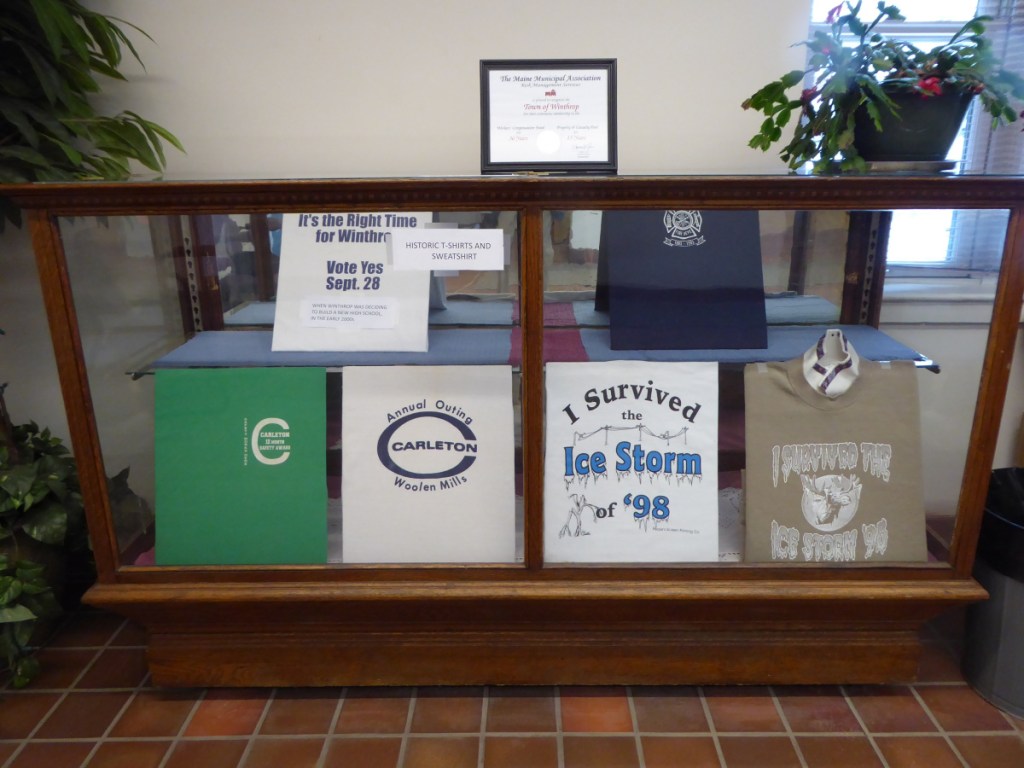 The display case in the Winthrop town clerk's room now features five historic T-shirts and a sweatshirt that refer to events in Winthrop's past.