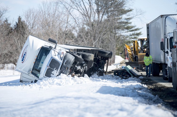 Crews prepare to transfer a payload of beer from one tractor-trailer to another Friday after the first rolled over on Trafton Road in Waterville when it hit a soft shoulder.