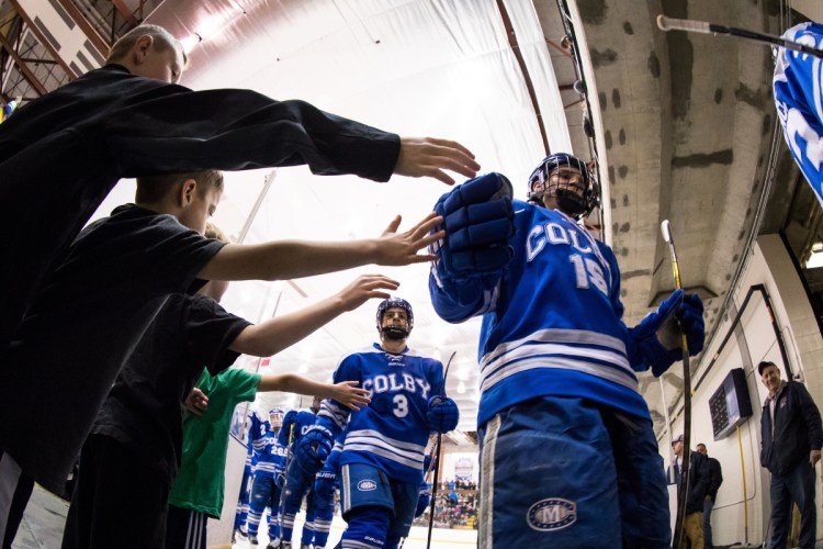 Young fans try to high-five Colby hockey players, including Mark Leprine (3) and Griffin Fadden (front) during an intermission of an NCAA Division III quarterfinal against SUNY Geneseo last March. Colby opens the new season this weekend at home with a pair of games.