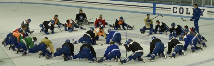 Colby College assistant hockey coach Chris Hall leads the team in stretches during practice Tuesday in Waterville.