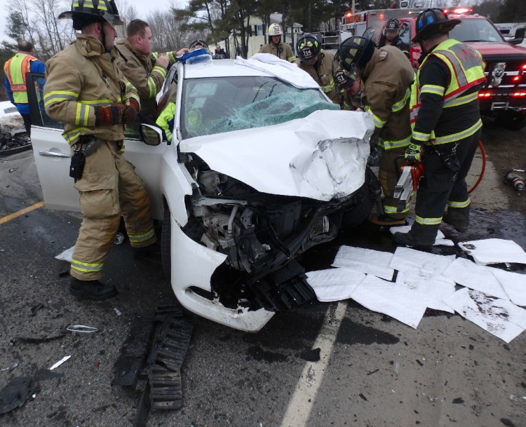 A crew from Winslow Fire and Rescue works to extricate Amos Christiansen on Wednesday evening from his 2014 Nissan Sentra after a head-on collision on Augusta Road in Winslow. Police say Christiansen might have fallen asleep at the wheel, causing him to cross the center lane into oncoming traffic.