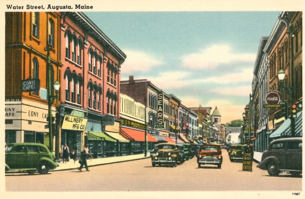This mid-20th-century postcard shows one-way traffic on Water Street looking south from Bridge Street in downtown Augusta.
