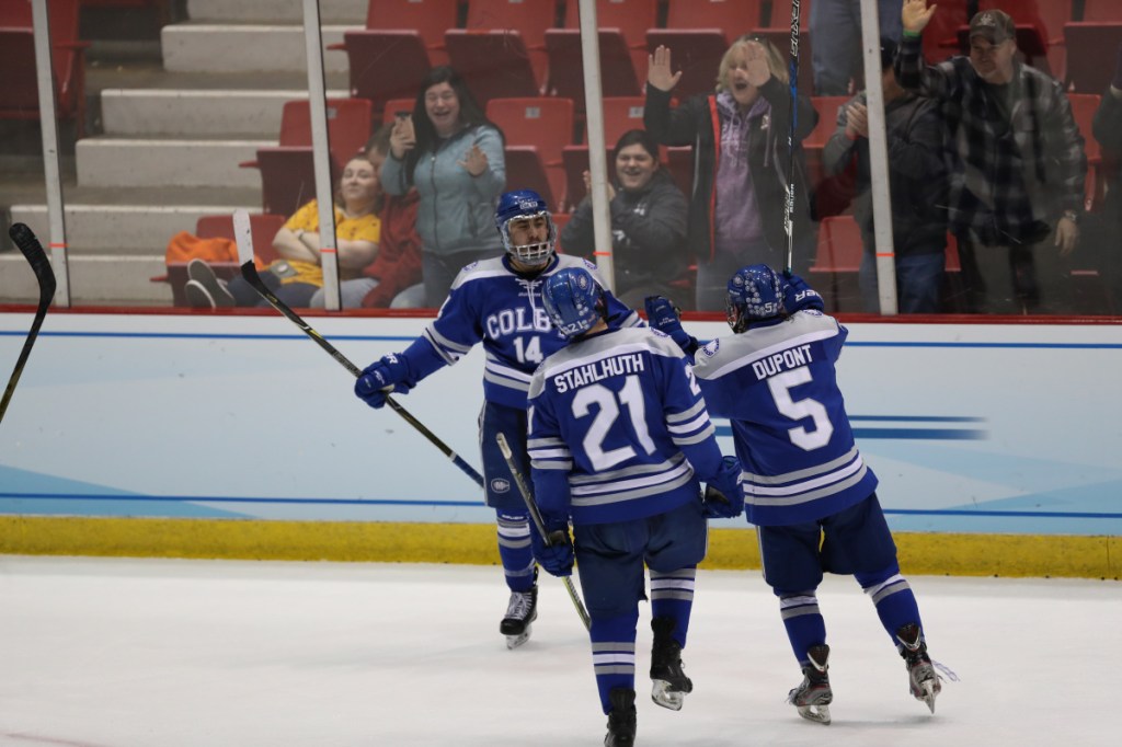 Colby players Cam MacDonald (14), Thomas Stahlhuth, Dan Dupont celebrate after the Mules pulled to within 3-2 against St. Norbert College during a Division III Frozen Four game Friday in Lake Placid.