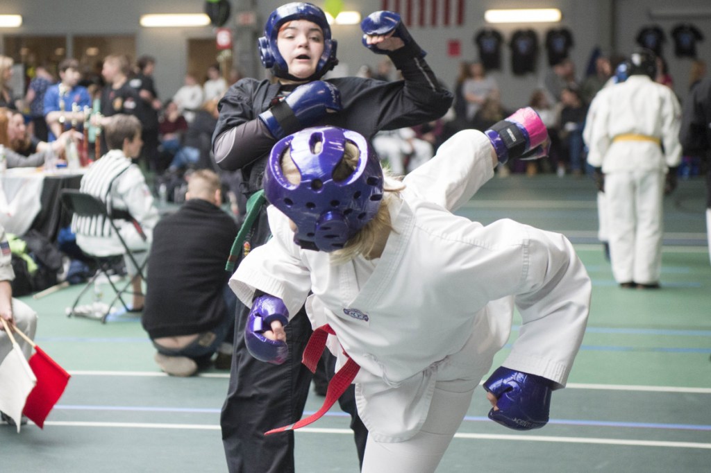 Staff photo by Michael G. Seamans 
 Lauren Heathcote, foreground, delivers a kick to Skyeler Poolis at the Battle of Maine Martial Arts tournament Saturday at Thomas College in Waterville.