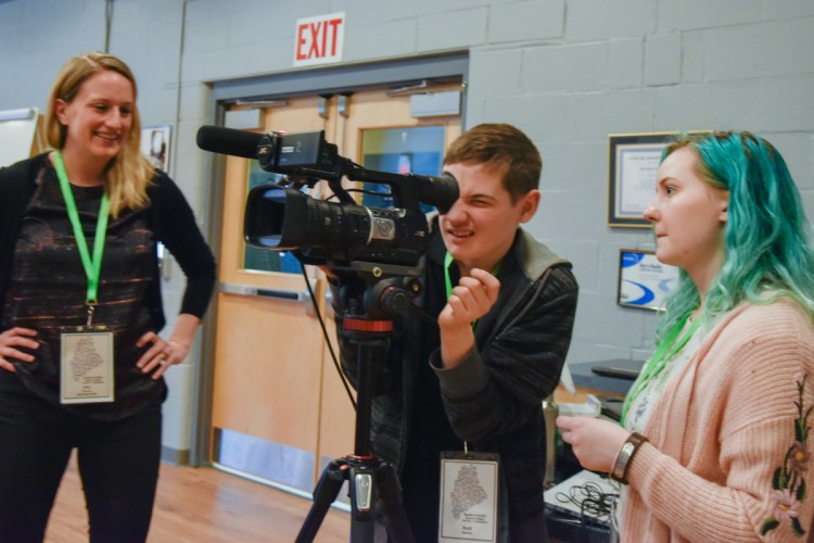 Kodi Quimby, center, 13 of Starks, looks through a video camera Saturday as documentary film instructor Erin Murphy, left, and student Sarah Thomas, 17, of Bangor, watch. The students are taking part in the Maine Student Film and & Video Conference in Waterville.
