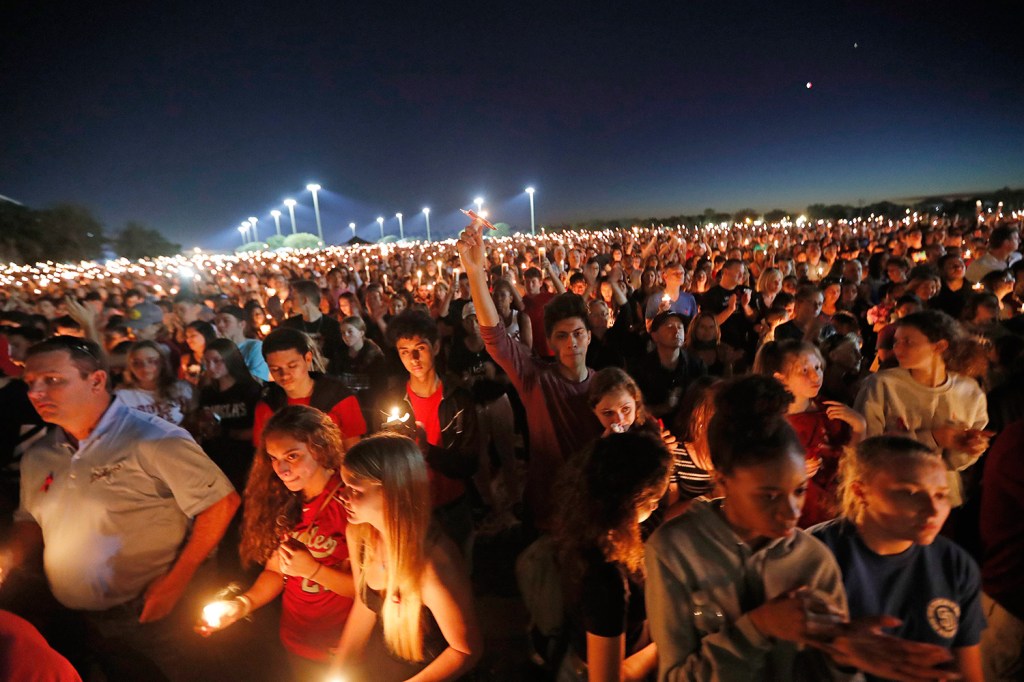 Hundreds hoist their candles during a vigil in Parkland, Fla., for the victims of a school shooting at Marjory Stoneman Douglas High School. 