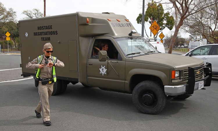 A hostage negotiation team passes a California Highway Patrol checkpoint at the Veterans Home of California on Friday after a gunman took hostages at the home. Police said Friday night that the gunman was not communicating with them.