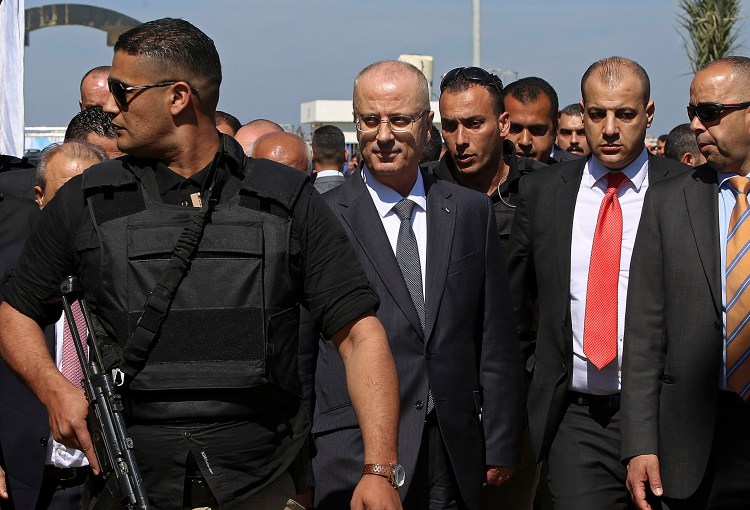 Palestinian Prime Minister Rami Hamdallah, center left, is surrounded by body guards Tuesday as he arrives for the opening ceremony for a long-awaited sewage plant project in the northern Gaza Strip. An explosion occurred as the convoy of the prime minister entered Gaza through the Erez crossing with Israel. The Fatah party of the prime minister called the explosion an assassination attempt and blamed Gaza militants.