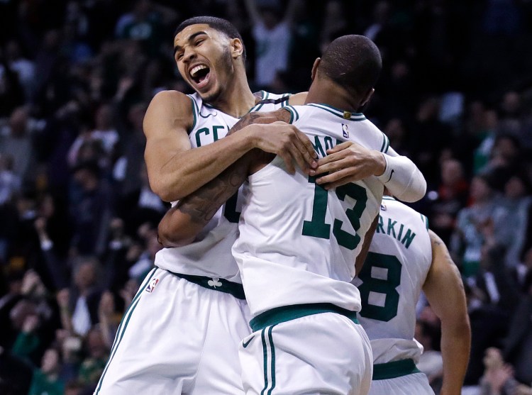 Boston's Marcus Morris leaps into the arms of Jayson Tatum as they celebrate Morris' winning 3-point shot Tuesday night in Boston.