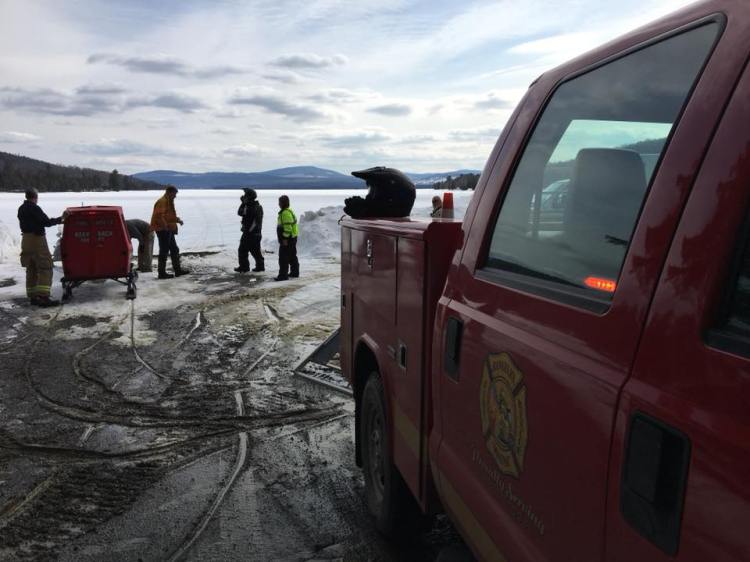 Members of the Rangeley Fire Rescue Department assist at a snowmobile accident on Rangeley Lake in Rangeley late Wednesday morning. It was the first of two crashes this week that injured snowmobilers who hit pressure ridges.