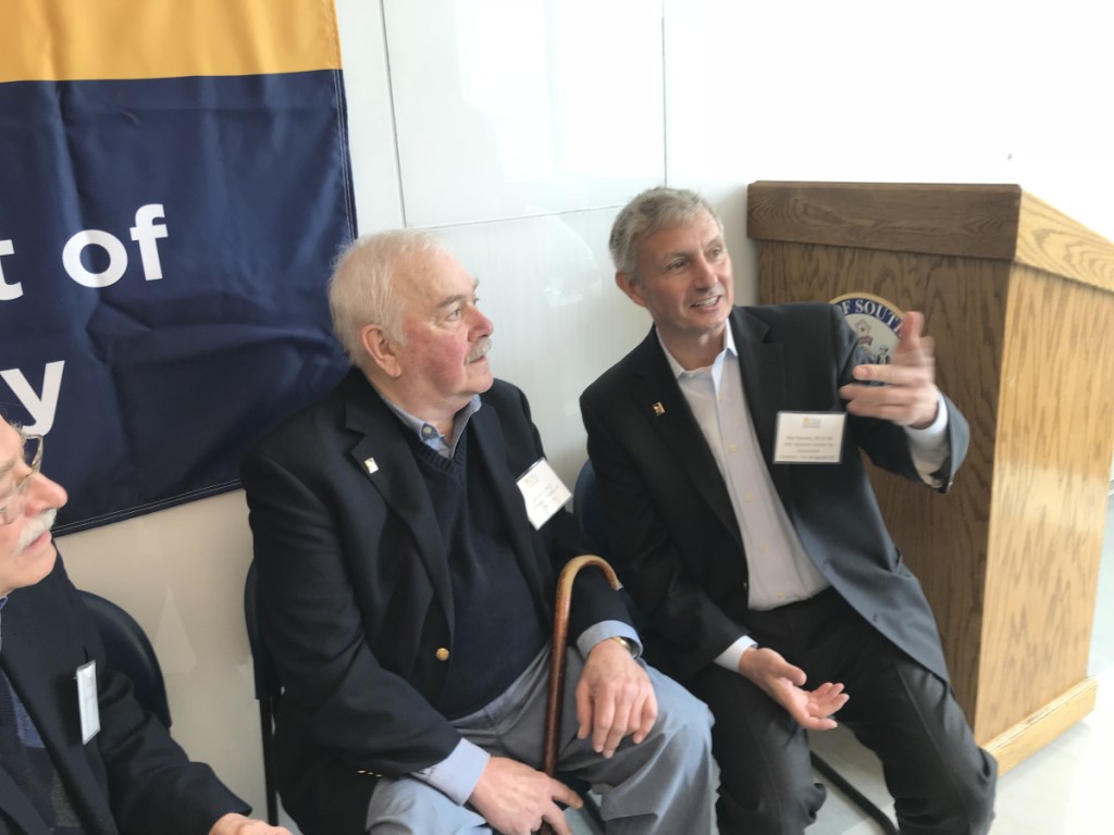 Benefactor Ray Stevens, right, and his onetime mentor, Professor Emeritus of Chemistry John Ricci, share a moment during Friday's 10-year celebration of the John Ricci Undergraduate Fellowship at the University of Southern Maine's Science Building in Portland.