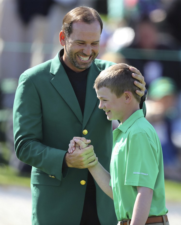 Sergio Garcia, the defending Masters champion, greets Nicholas Gross of Downington, Pa., after Gross' shot on the 18th green won the putting title for his age group Sunday.
