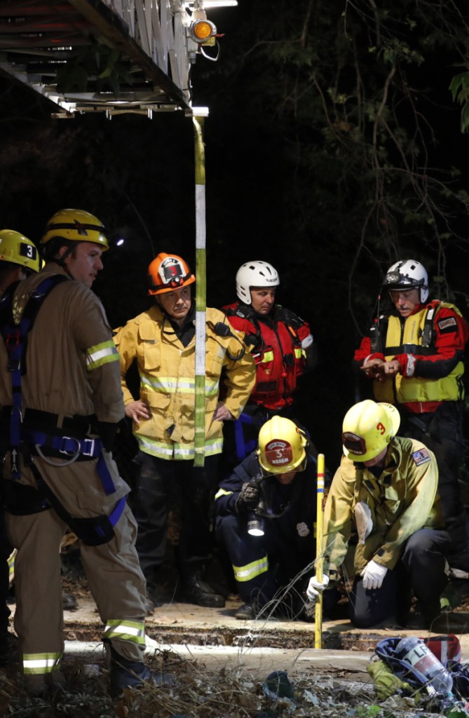 Firefighters search for a 13-year-old boy in a hole Sunday in Los Angeles. The boy was found alive early Monday following a frantic, 12-hour search.