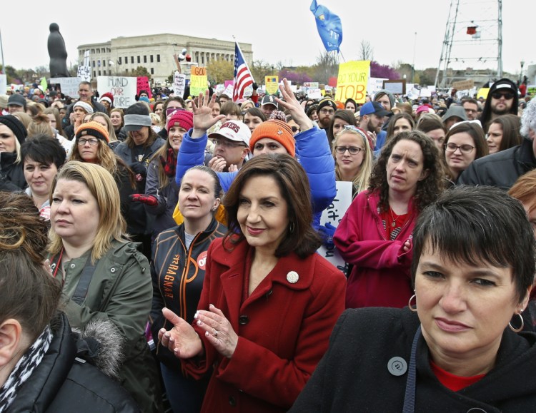 Oklahoma's State Superintendent of Public Instruction Joy Hofmeister, center, applauds during a rally in Oklahoma City. Oklahoma teachers walked out for a second day Tuesday.