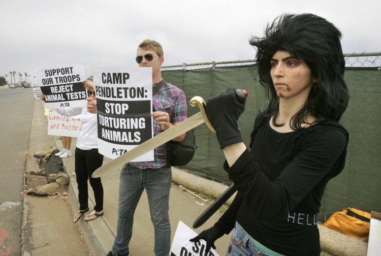 Nasim Aghdam, right, joins members of People for the Ethical for Animals protesting at the main gate of Marine Corps' Camp Pendleton in Oceanside, Calif., in August 2009. Law enforcement officials have identified her as the person who opened fire with a handgun Tuesday at YouTube headquarters in San Bruno, Calif., wounding three people before fatally shooting herself.
