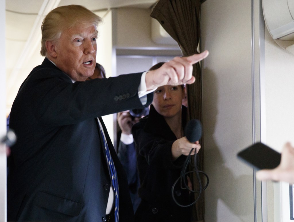 President Trump talks with reporters Thursday aboard Air Force One. He says China's "illicit" trade practices "have destroyed thousands of American factories and millions of American jobs."