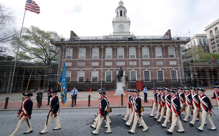 A regiment marches past Independence Hall in opening ceremonies for the Museum of the American Revolution in Philadelphia. The museum includes the previously untold roles played by Native Americans, blacks and women.