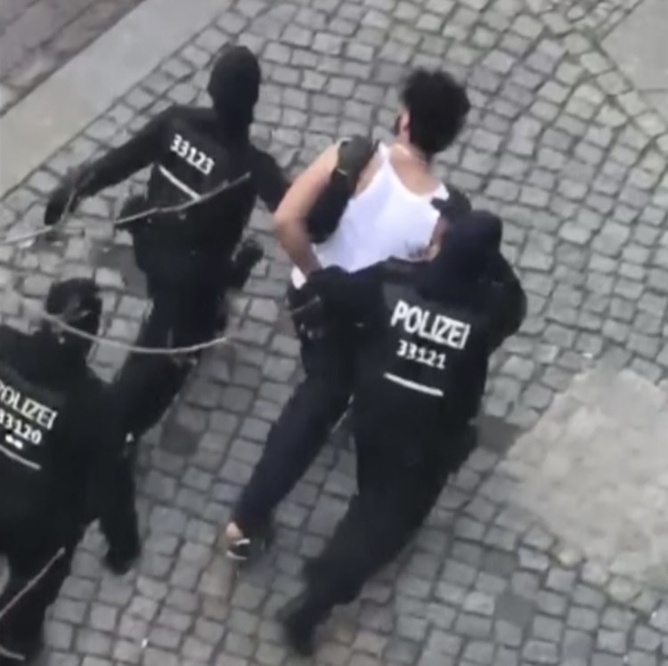 A suspect is led away by police in Berlin on Sunday. He was one of six people detained in connection with a suspected plan to attack the city's half-marathon.