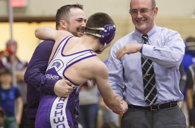 Marshwood's 126-pound wrestler Liam Coomey celebrates a victory over Noble's Sam Martel with coaches Pat Howard and Matt Rix (right) during the Class A state wrestling championship in Sanford on February 17.