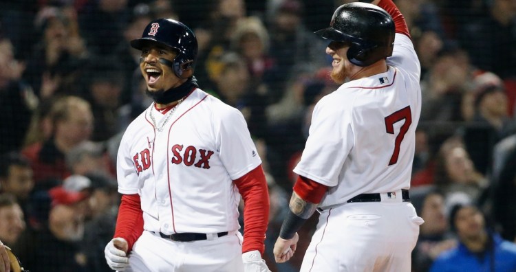 Boston Red Sox's Mookie Betts, left, celebrates with Christian Vazquez (7) after scoring on a triple by Andrew Benintendi during the second inning of a baseball game against the New York Yankees in Boston, Tuesday, April 10, 2018. ()