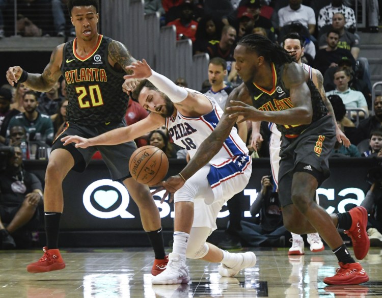 Philadelphia's Marco Belinelli has the ball stolen by Atlanta's Taurean Prince, right, as John Collins looks on during the second half Tuesday night in Atlanta.