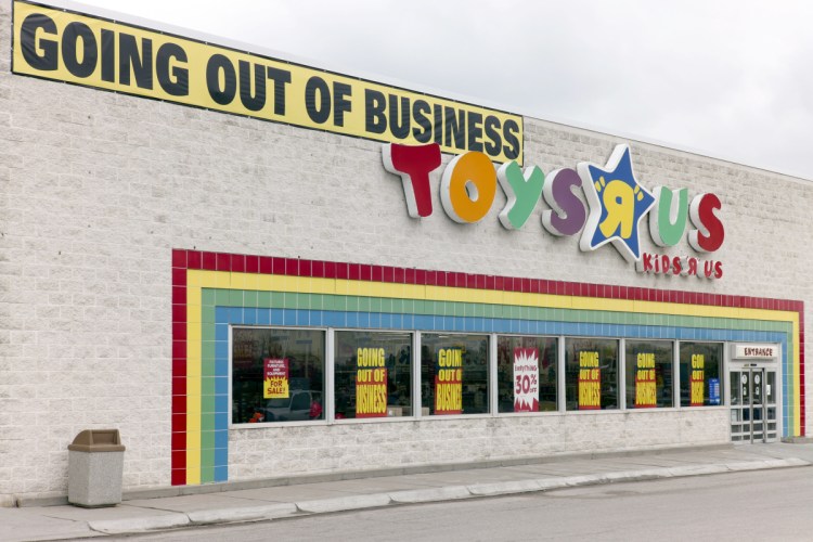 A "Going Out Of Business" sign hangs over the Toys R Us store logo in Omaha, Neb., on Monday.