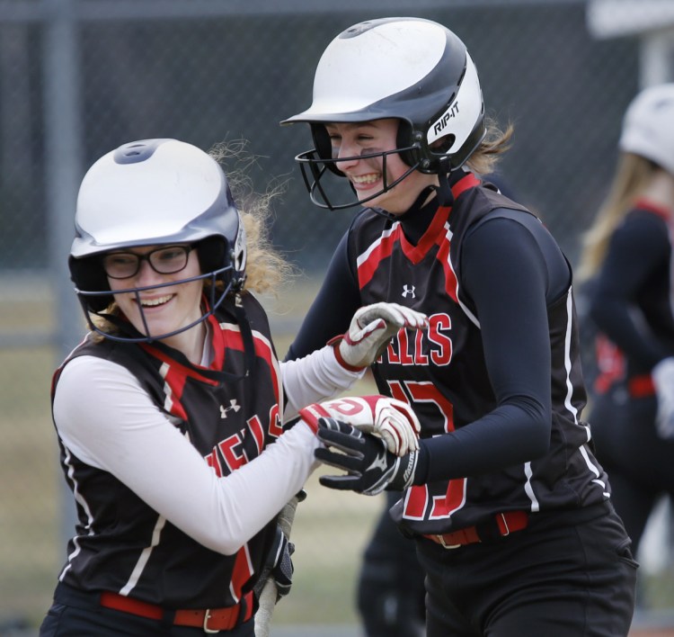 Sam Bogue of Wells, right, celebrates her three-run homer with teammate Olivia Clay in the fifth inning of a 6-0 victory against Greely to open the Western Maine Conference softball season Thursday.