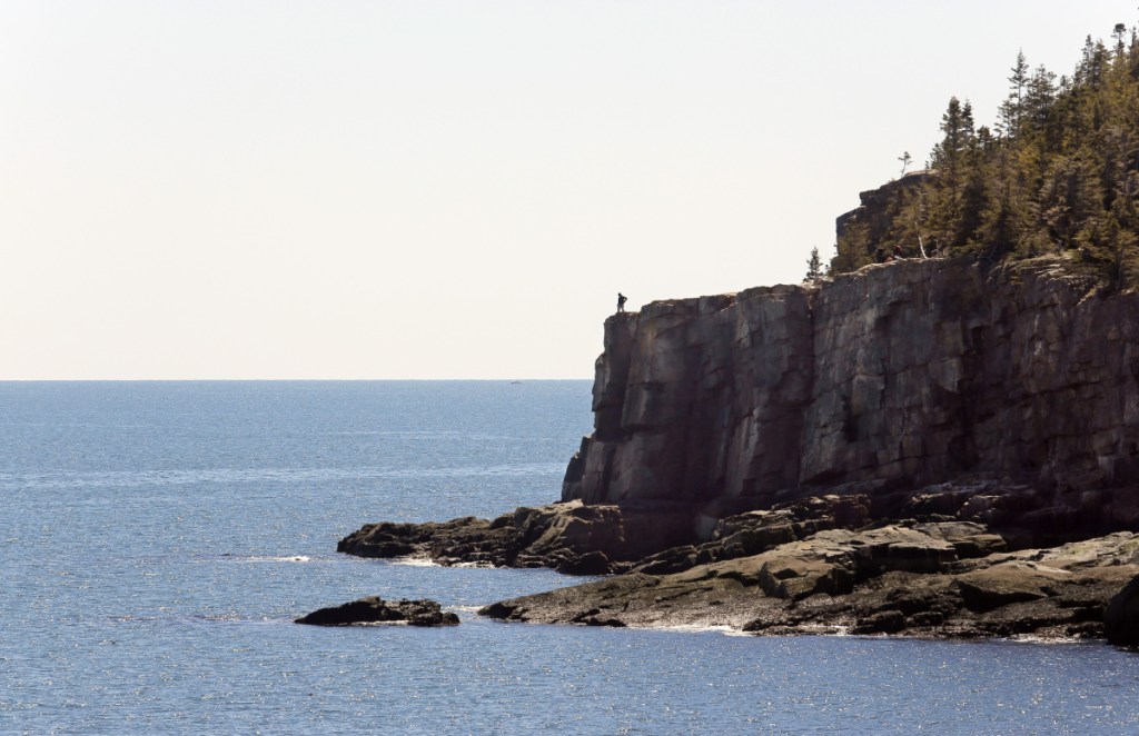 MOUNT DESERT ISLAND, ME - APRIL 30: A lone visitor looks out over the ocean from Otter Cliffs in Acadia National Park on Saturday, April 30, 2016. Many locals take advantage of the quiet shoulder seasons in spring and fall, when the crowds are absent from the park. (Photo by Gregory Rec/Staff Photographer)
