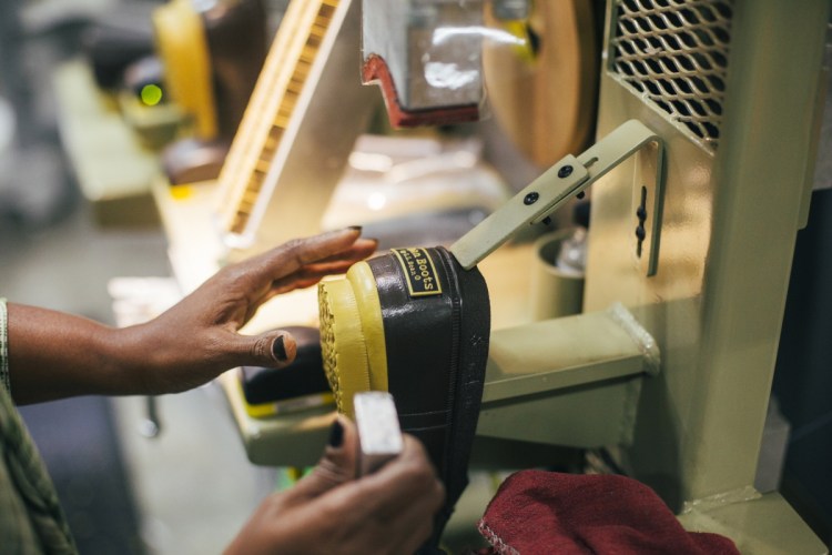 Yasmin Abdille places an L.L. Bean logo onto the back of the boots at their manufacturing facility in Brunswick in 2015.