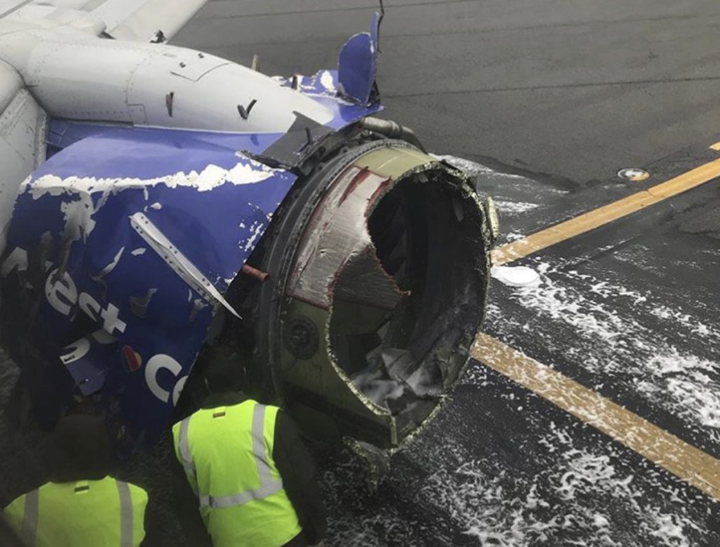 The engine on a Southwest Airlines plane is inspected as it sits on the runway at the Philadelphia International Airport after it made an emergency landing in Philadelphia, on Tuesday.