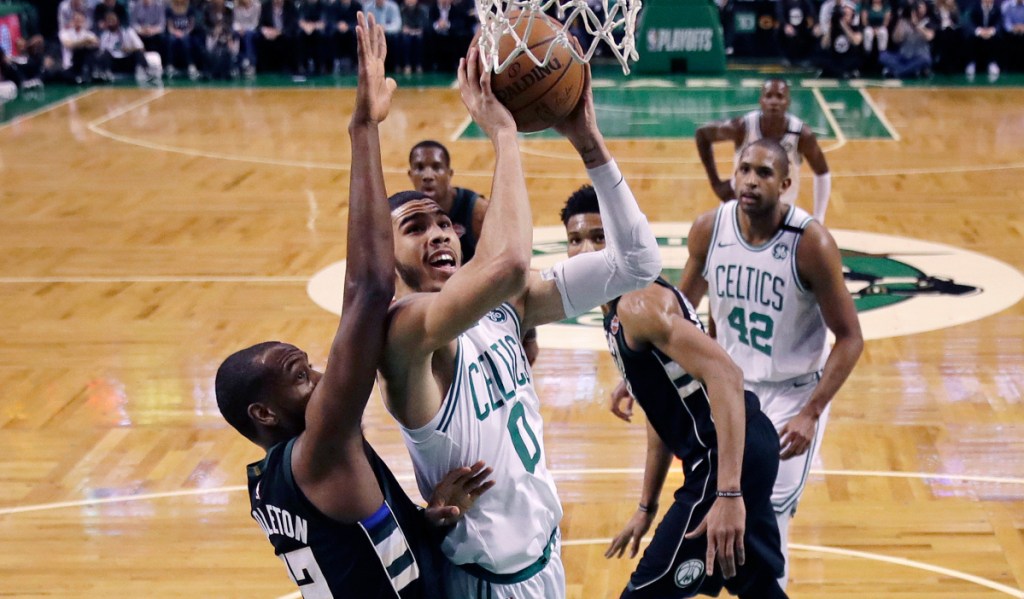 Boston's Jayson Tatum drives to the basket against Milwaukee forward Khris Middleton, left, during the first quarter of Tuesday Game 2 in Boston. The Celtics won to take a 2-0 series lead.