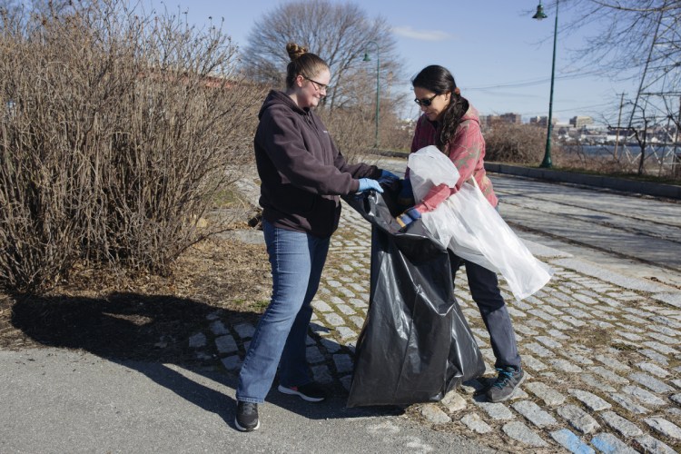 Nicole Malpass, left, of Gorham and Christine Bodnar of Standish pick up litter at Thomas Knight Park in South Portland on Saturday.