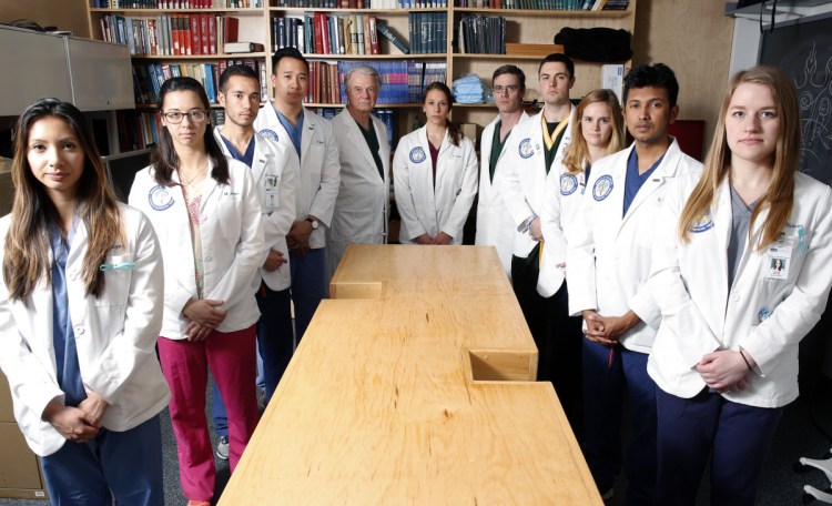 University of New England students and staff surround a bare cadaver table. UNE has the state's only licensed medical school with a whole-body donation program.