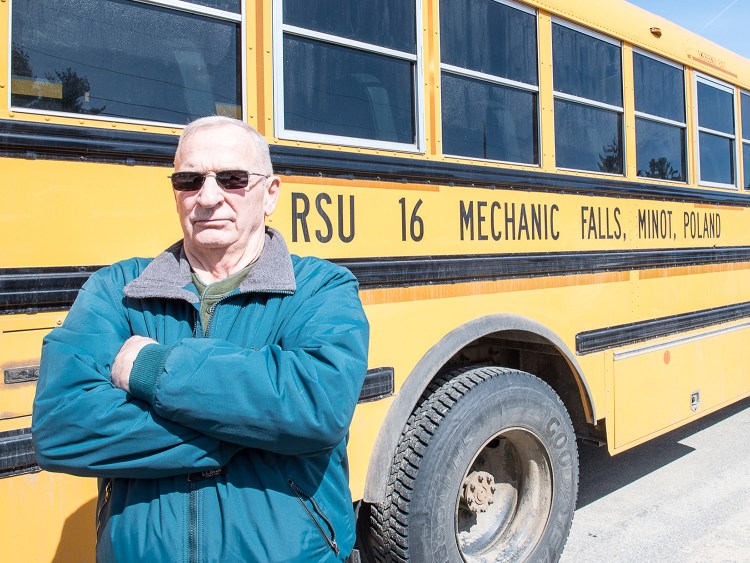 Mike Downing stands in the RSU 16 bus depot in Poland in March. Downing was fired in January for making racist and sexist comments and has since been elected to the board of the school system that fired him.
