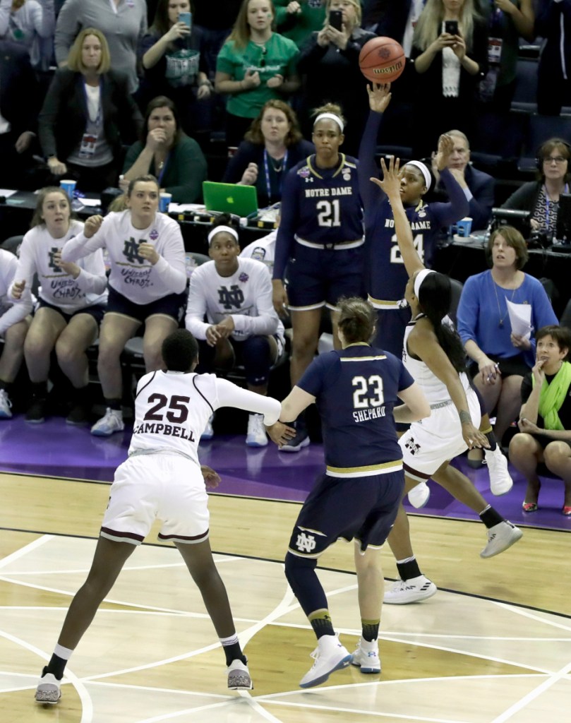 Notre Dame's Arike Ogunbowale, top, sinks a 3-point basket to defeat Mississippi State 61-58 to win the NCAA women's national championship in Columbus, Ohio.