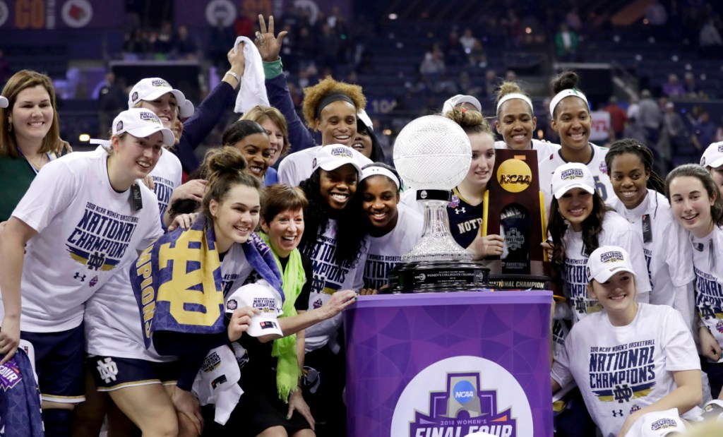 Members of the Notre Dame women's basketball team celebrate with the trophy after defeating Mississippi State for the national championship Sunday in Columbus, Ohio.