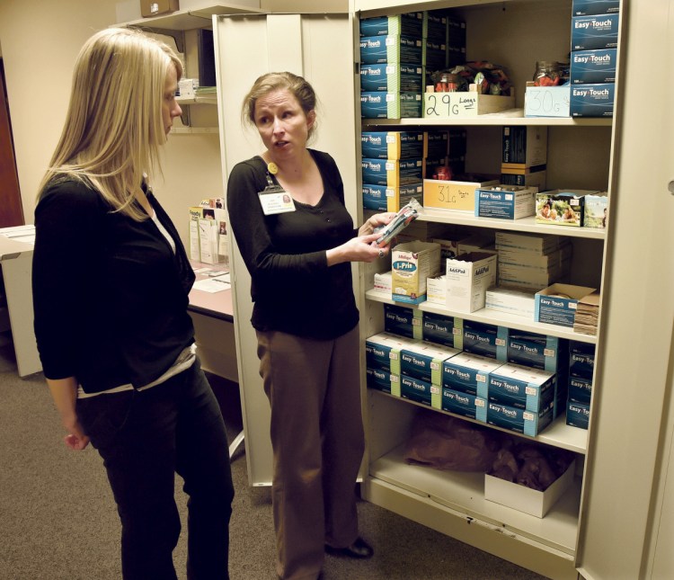 Joy McKenna, right, director of Marketing at Maine General, on Monday shows sterile hypodermic needles and other supplies to Nicole Poulin, of the Prevention and Healthy Living department, in a room at the Thayer Center for Health in Waterville that will be used for a needle exchange and counseling program for drug users.