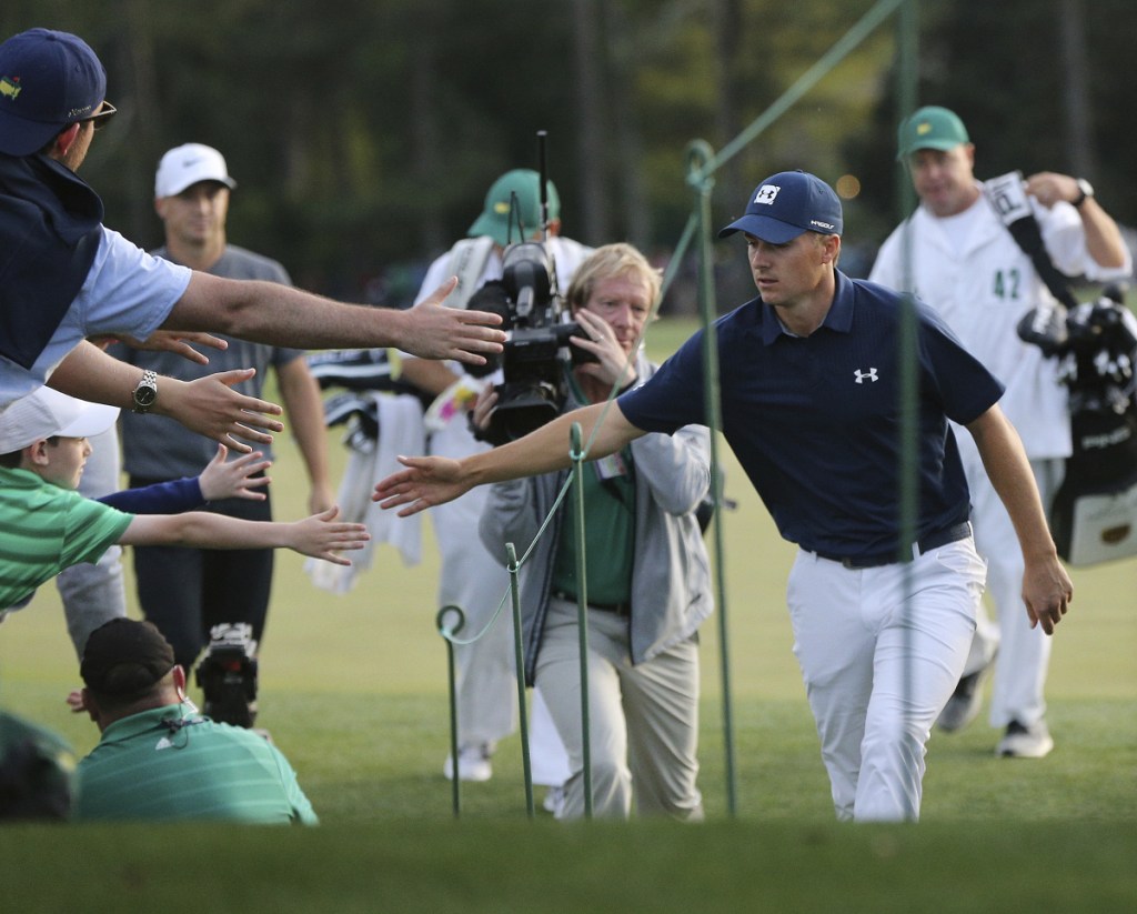 Jordan Spieth, front right, greets fans five as he leaves the 18th green during the first round at the Masters on Thursday in Augusta, Georgia.