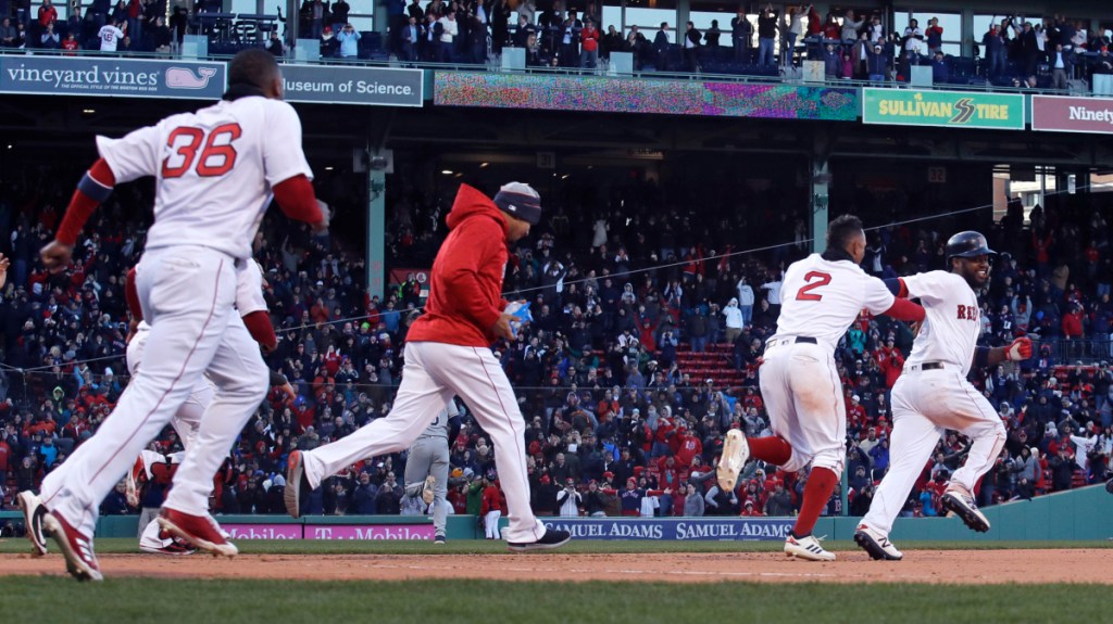 Boston Red Sox designated hitter Hanley Ramirez, right, is chased by teammates as he celebrates after his bases-loaded walkoff single in the twelfth inning Thursday against the Tampa Bay Rays at Fenway Park in Boston.