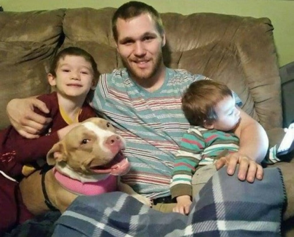 Mitchell MacArthur Jr., sits flanked by his sons Logan (left) and Owen, and Sabrina, the rescue dog the family adopted that alerted MacArthur to a fire in his Somerset Ave. home in Fairfield Sunday night.