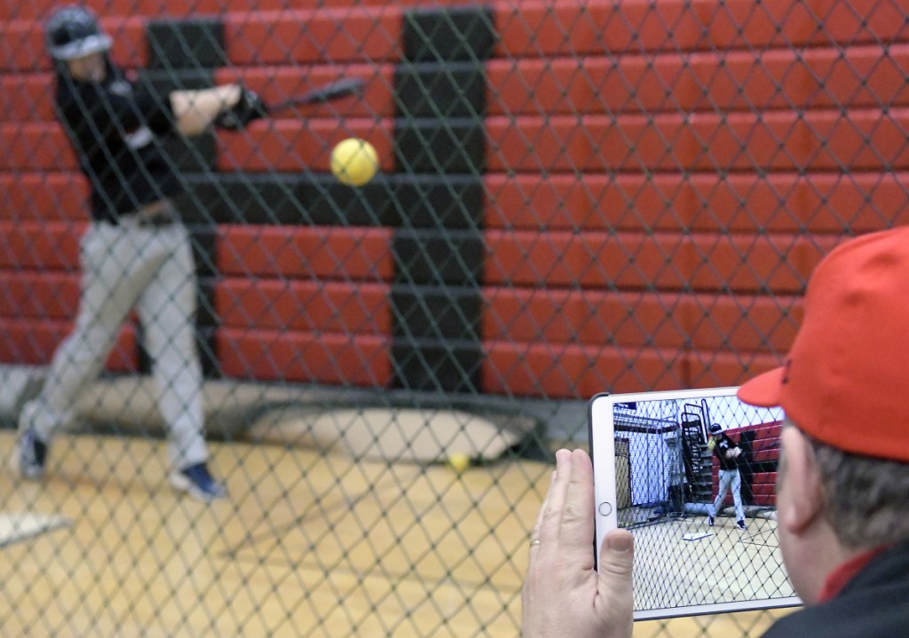 Hall-Dale High School coach Bob Sinclair records hitters during an April 4 practice.