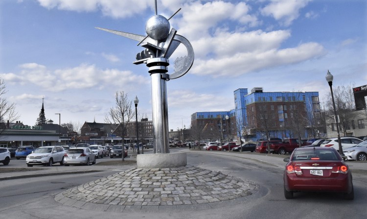 A vehicle negotiates the turn around "The Ticonic" sculpture Thursday in the middle of the Concourse in Waterville. The City Council expects to consider on Tuesday spending money to move the sculpture to the Head of Falls area.