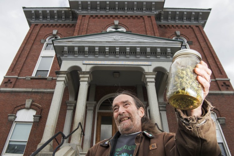 Donnie Christen poses for a portrait Friday in front of the Somerset County Courthouse in Skowhegan while holding an ounce of marijuana.