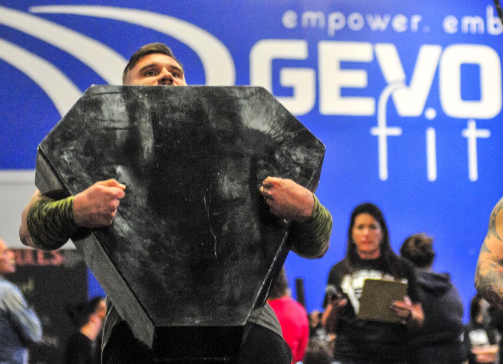 C.J. Viera carries the 100 pound metal box with two chains in it during the Men's Novice Husafell Carry on Saturday at the Central Maine Strongman contest in Augusta.