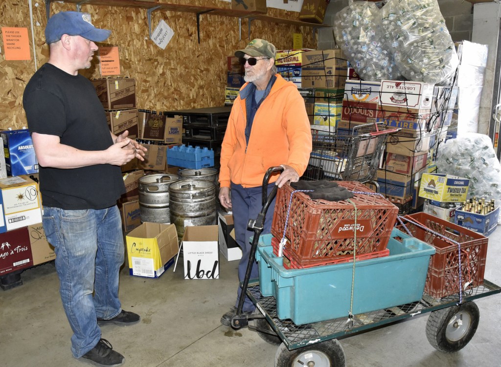 Harold LaBrie, right, speaks with Damon's Beverage employee Bobby Frappier after bringing returnable cans and bottles in a cart to the redemption room in Waterville on Wednesday. LaBrie's bike that he used to transport containers was stolen and Frappier offered him a bike for free.