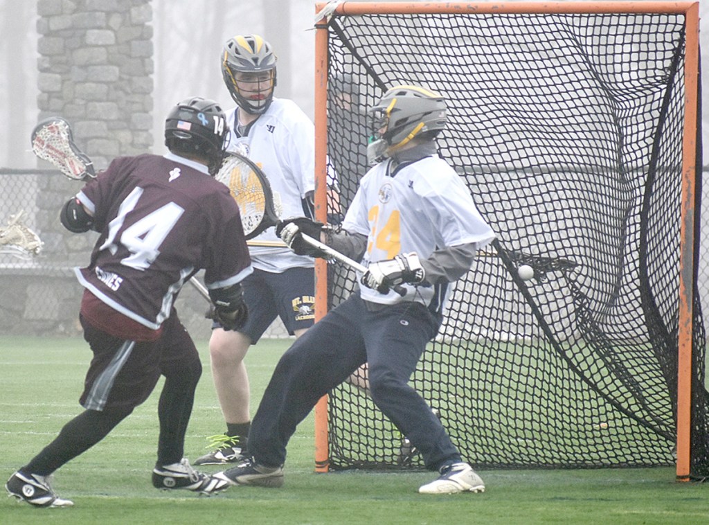 Edward Little's Ben Feldman (14) scores one of his three goals against Mt. Blue goalie Brian Hayes (34) on Tuesday at Kents Hill School.