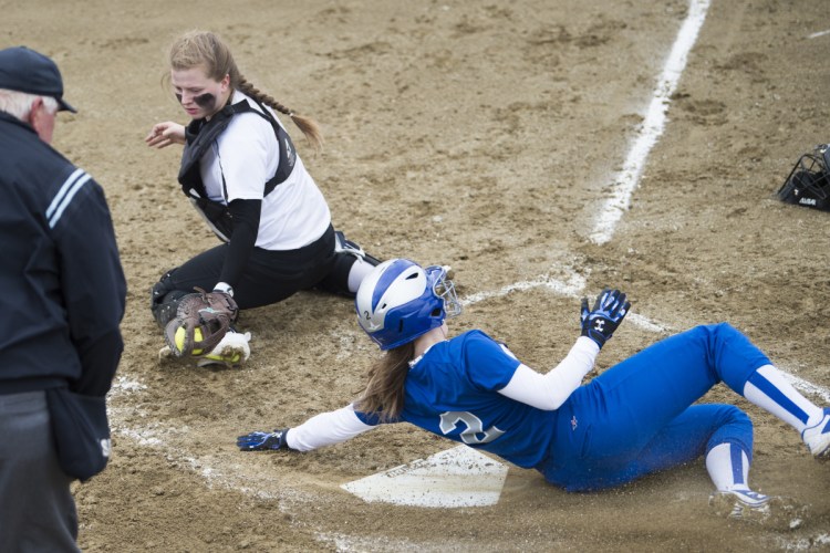 Lawrence's Megan Curtis (2) slides safely across home plate before Maine Central Institute catcher Maria Reed can apply the tag Friday in Fairfield.