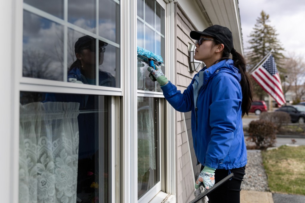 Viki Lin, of New Orleans, La., washes the exterior windows of the Sunset Home of Waterville Maine, an assisted living community for older women, as part of the Colby Cares Day. Colby students, as well as faculty and staff members, did community service projects Saturday throughout Waterville.
