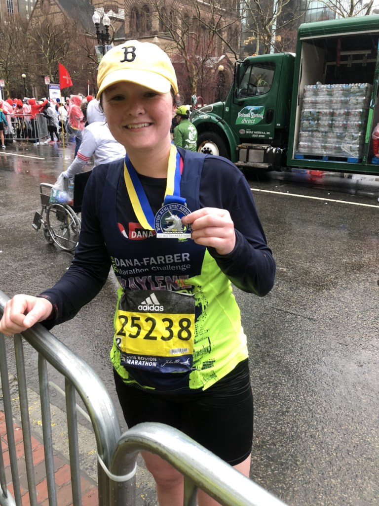 Kaylene Murphy shows off her Boston Marathon medal. Murphy completed the marathon after spending 46 days in the hospital beginning in early December.