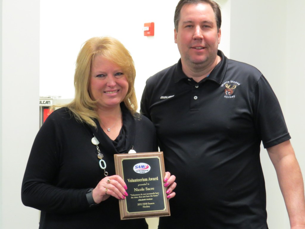 An outstanding volunteerism award was presented to SAM registrar Nicole Sacre, left, from Pittston, by Dan Foster, chair of the hockey committee during the annual meeting at the Camden National Bank Ice Vault in Hallowell.